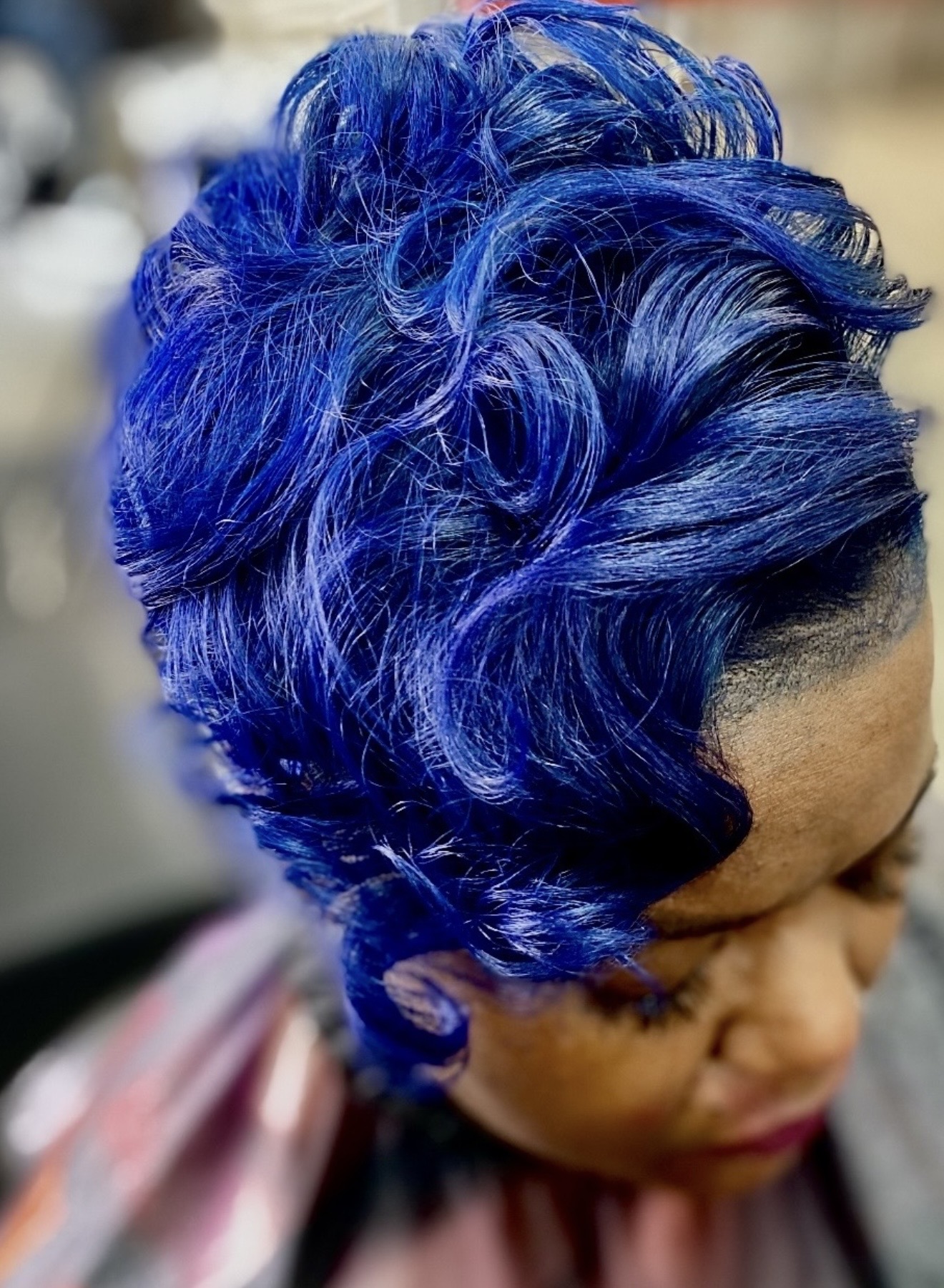 Vivid blue curled hairstyle by Genetik Bleu Salon